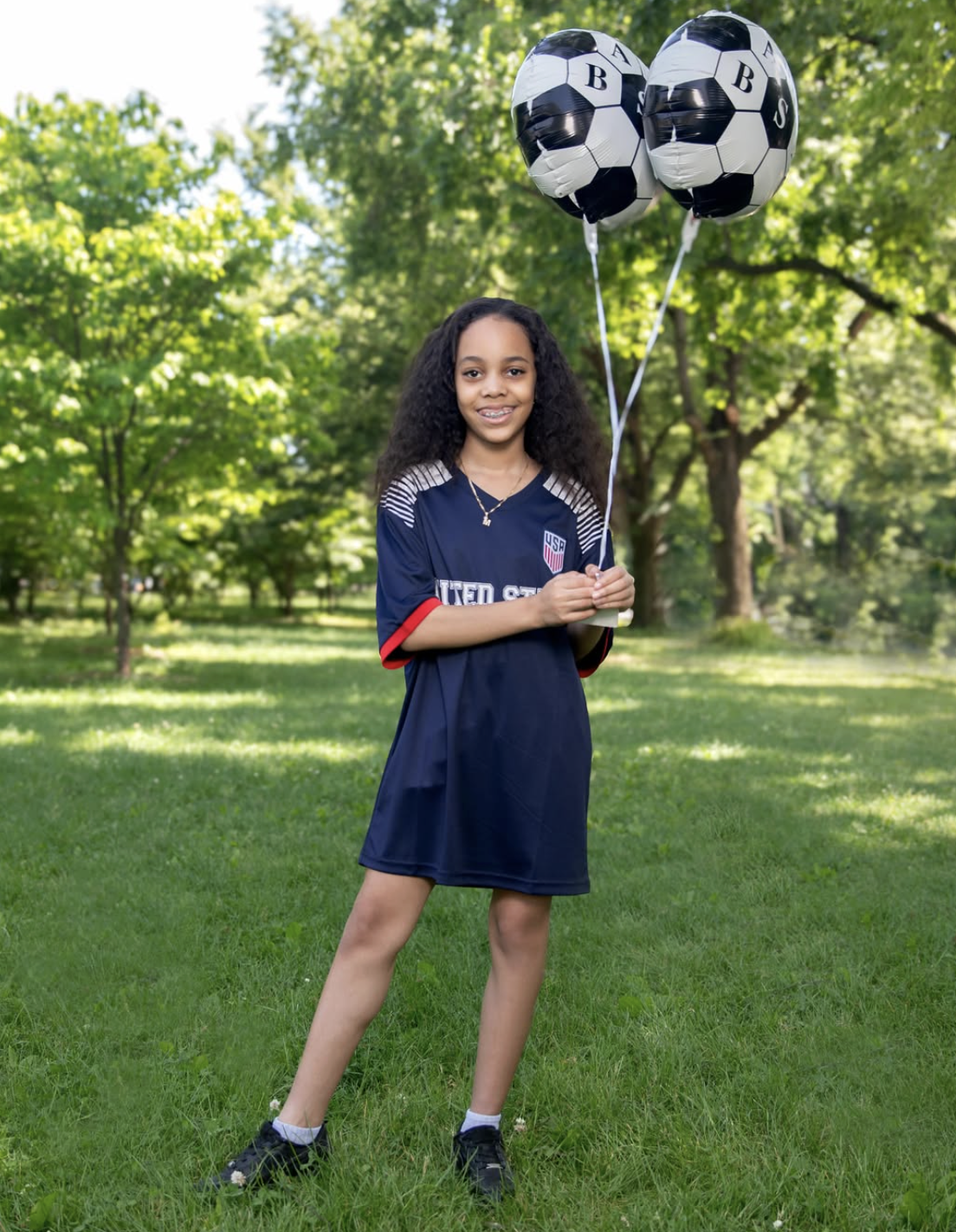 Young fan in USA jersey holding SourAppleBXNYC soccer balloons