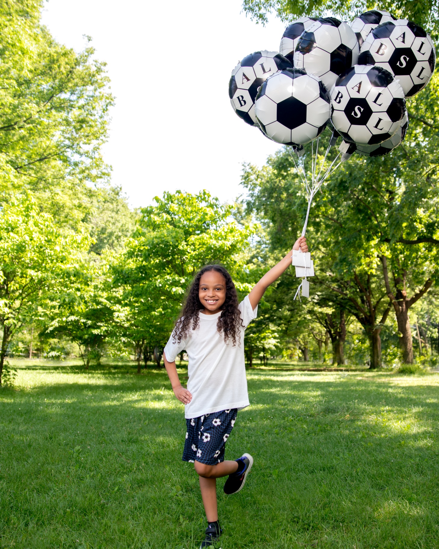 Girl running with a bunch of SourApple soccer balloons